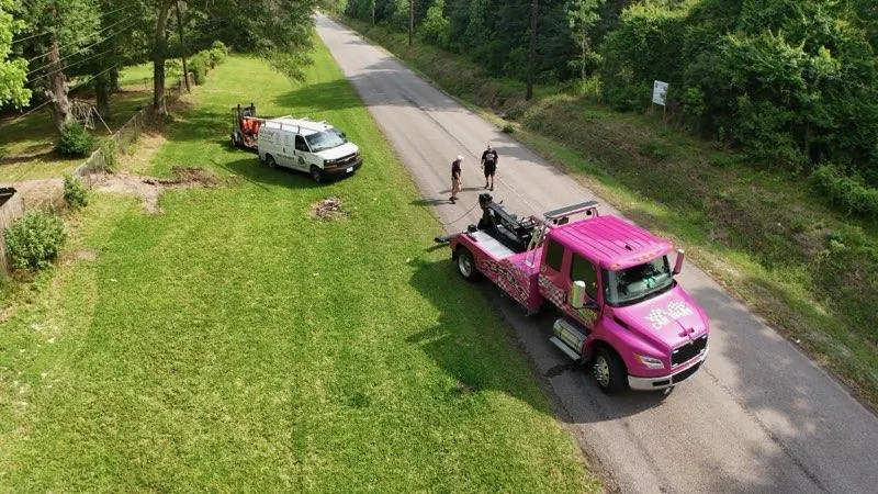 Aerial view of Car Wars Towing pink wrecker on the job in Orange, TX