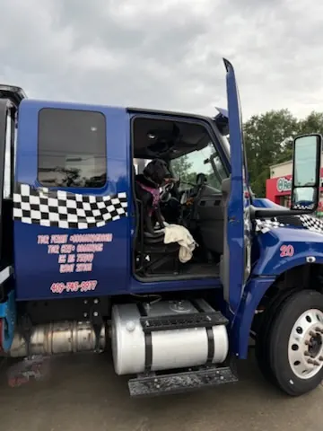 Car Wars Towing shop dog looking out the pink truck window in Orange, TX