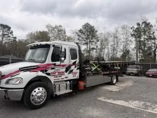 Car Wars flatbed safely transporting a red Honda Goldwing motorcycle in Orange, TX