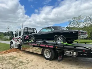 Car Wars flatbed transporting a blue pickup truck in Orange, TX