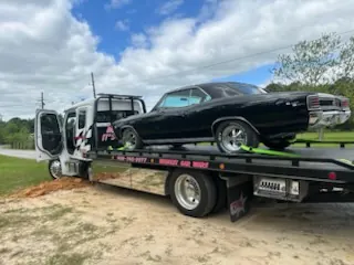 Pink Car Wars flatbed with classic green Cadillac at gas station, 24-hour service Orange, TX