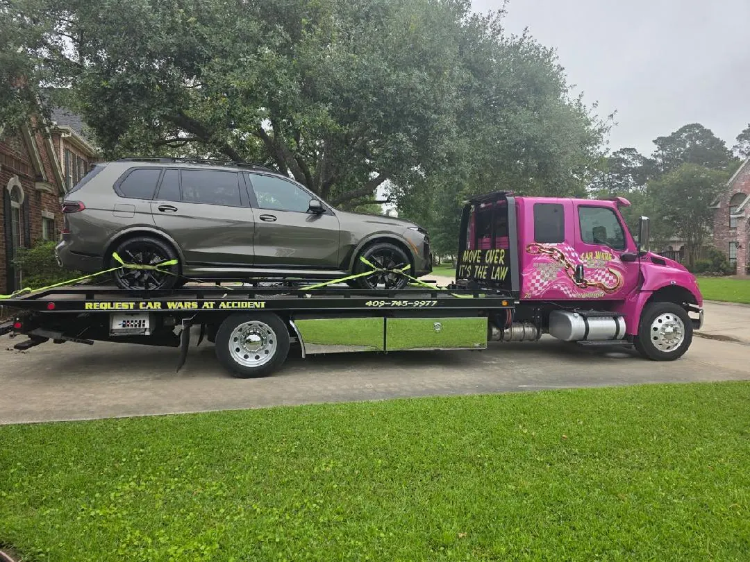 Two pink Car Wars Towing trucks responding to a job in Orange, TX